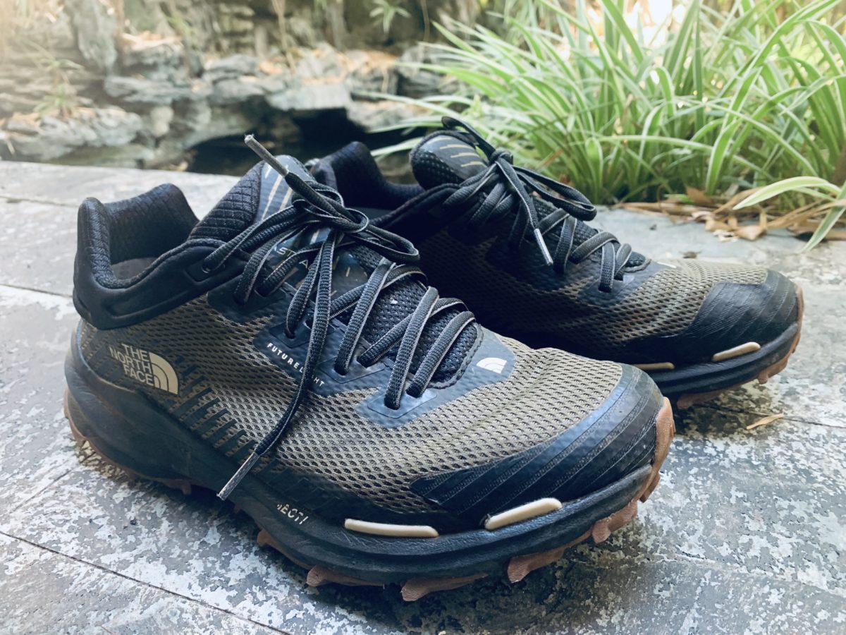 A side view of the The North Face Vectiv Futurelight hiking shoes outside near a pond, men's footwear review